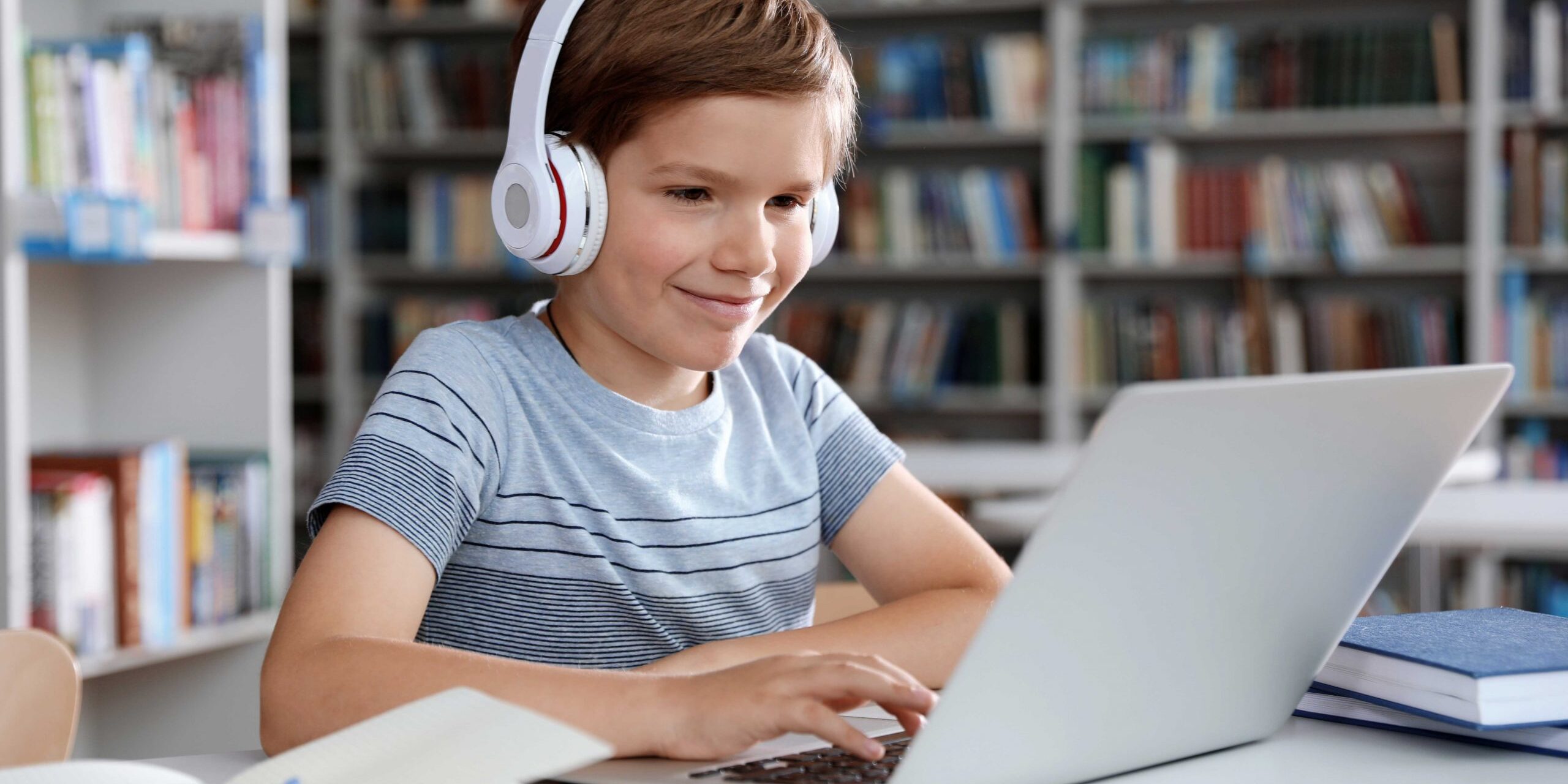 Pojke med dator och hörlurar